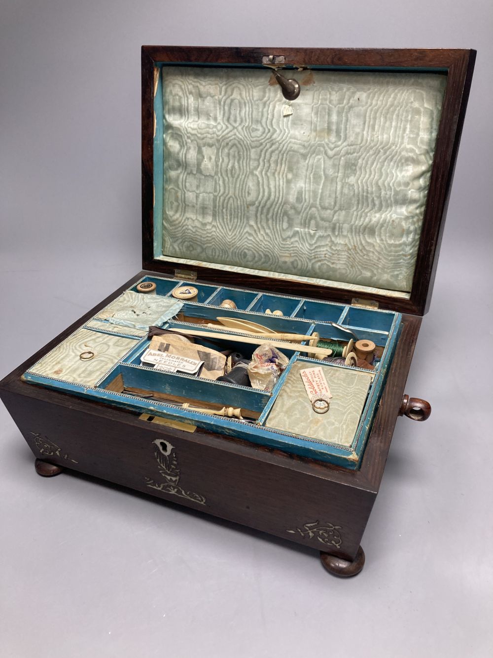 A Victorian mother of pearl-inlaid rosewood sewing box, containing various accessories, lace bobbins, etc.